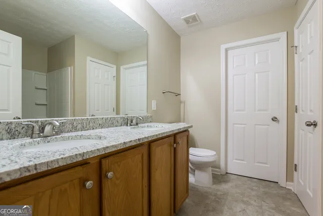 a bathroom with a sink mirror and toilet