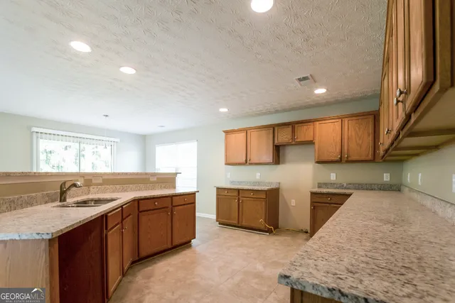 a kitchen with stainless steel appliances granite countertop a sink and a stove