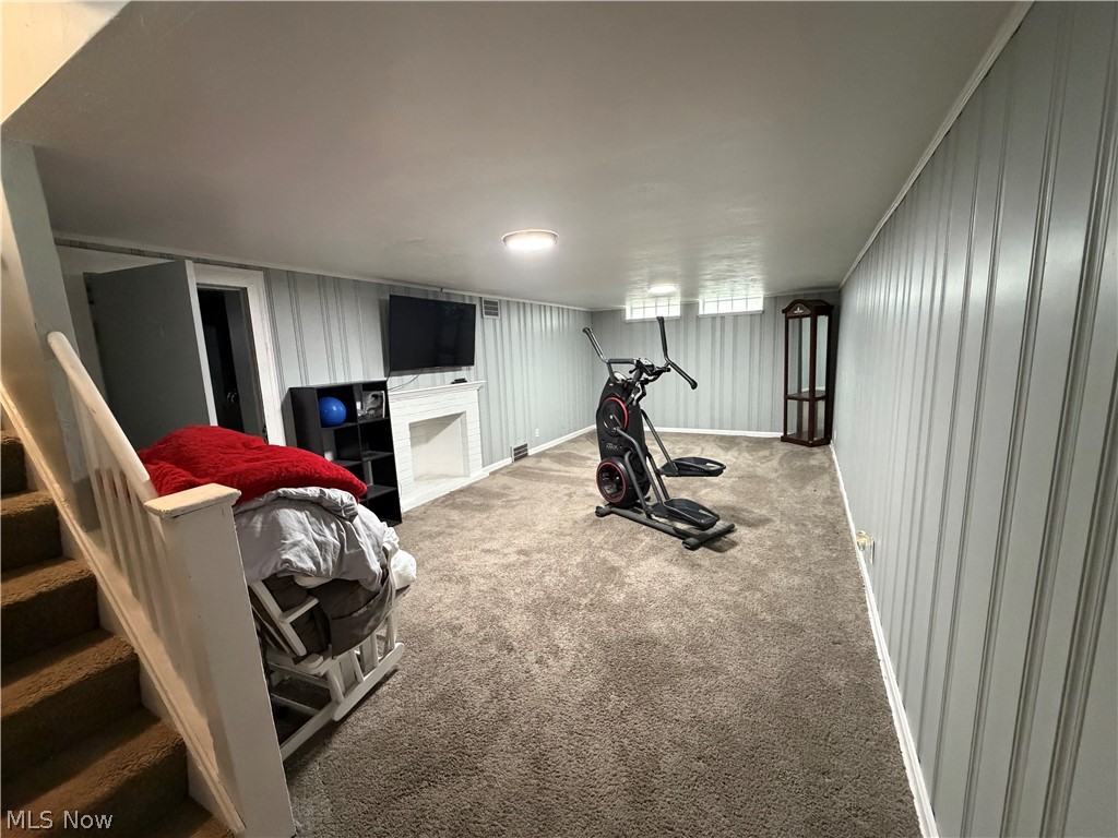 3714 Avalon Road Shaker Heights, OH 44120 - Photo 36 of 46 Finished basement space featuring light gray paneling, neutral carpet flooring, and a white decorative fireplace mantel
