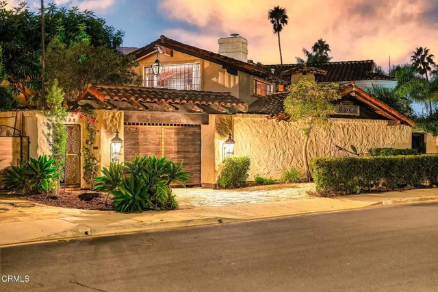 a front view of house along with road and trees