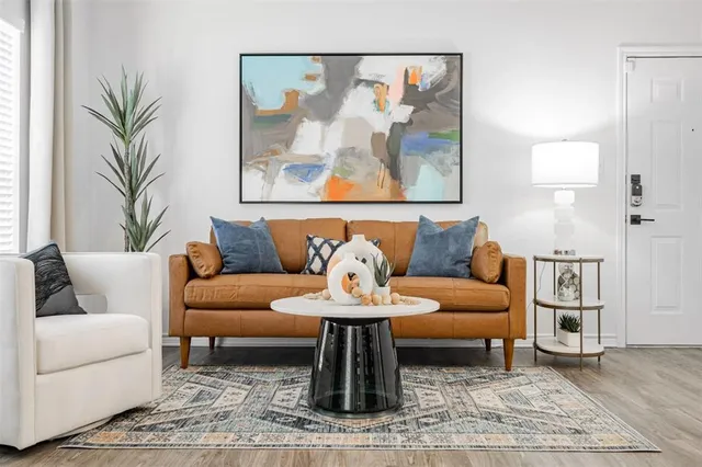 a living room with furniture and painting on the wall