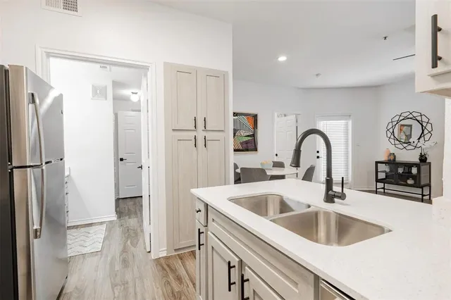 a kitchen with a refrigerator sink and cabinets