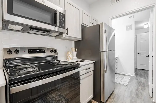 a kitchen with a refrigerator sink and cabinets