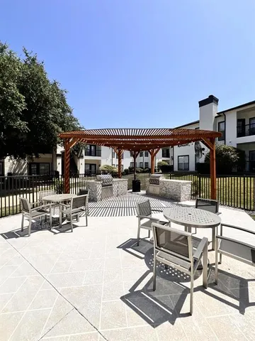a roof deck with table and chairs and potted plants