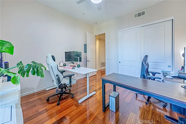 a view of a workspace room with wooden floor and dining table