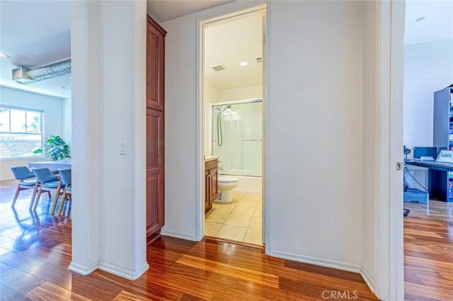 a view of a hallway with wooden floor and dining room