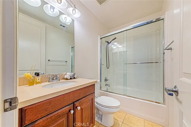 a bathroom with a sink a toilet a mirror and shower