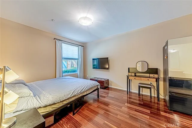 a bedroom with a bed and a table with wooden floor
