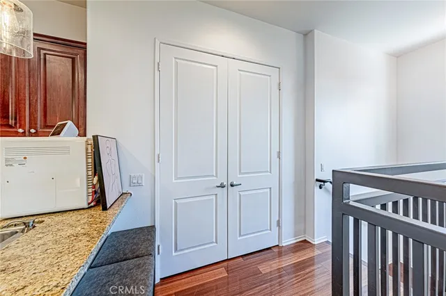 a view of a hallway with wooden floor and closet