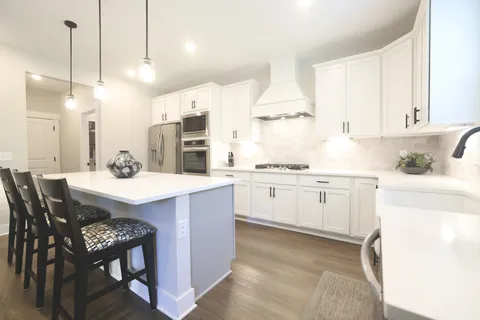 a kitchen with stainless steel appliances a refrigerator sink and microwave