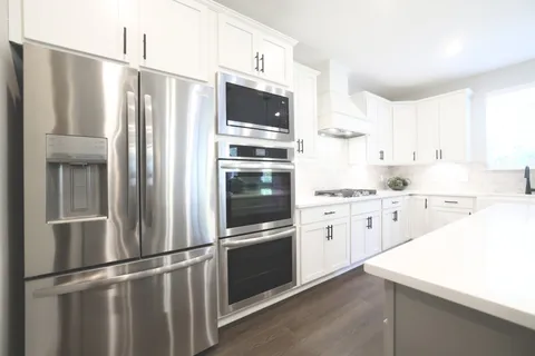 a white stove top oven sitting inside of a kitchen
