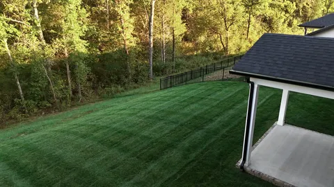 a view of a backyard with barn and wooden fence