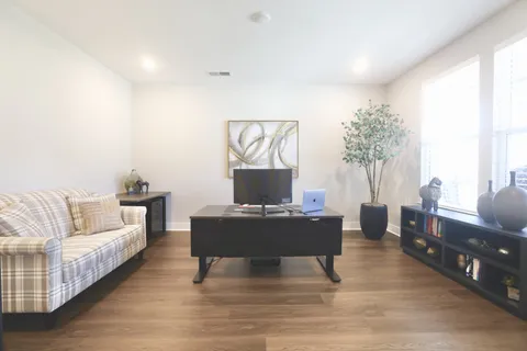 a living room with furniture kitchen view and a large window