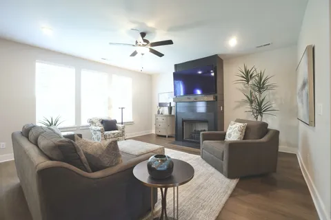 a living room with furniture kitchen view and a chandelier