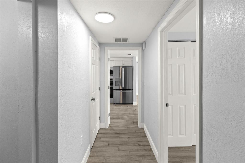 13916 Sommers Avenue Hudson, FL 34667 - Photo 16 of 46 a view of a hallway with wooden floor and a bathroom