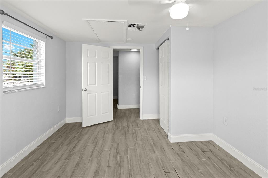 13916 Sommers Avenue Hudson, FL 34667 - Photo 18 of 46 an empty room with wooden floor and windows