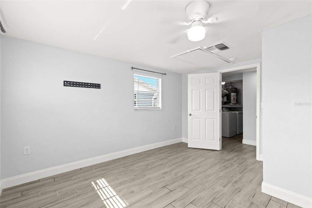 13916 Sommers Avenue Hudson, FL 34667 - Photo 19 of 46 an empty room with wooden floor chandelier fan and windows