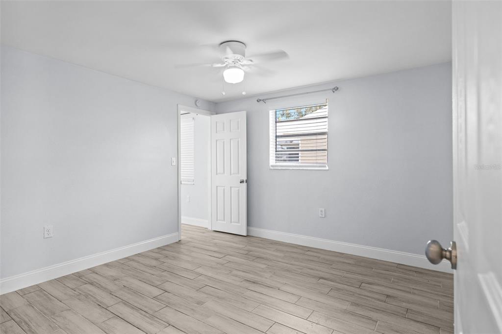 13916 Sommers Avenue Hudson, FL 34667 - Photo 23 of 46 a view of an empty room with wooden floor and a window