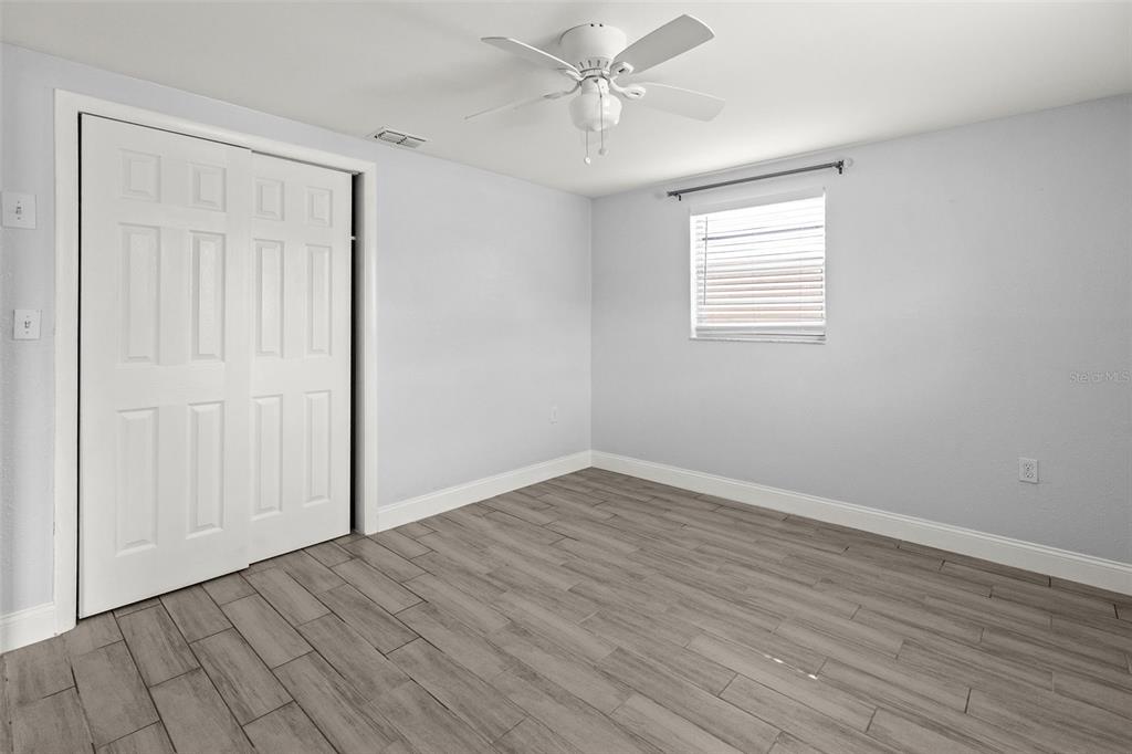 13916 Sommers Avenue Hudson, FL 34667 - Photo 27 of 46 a view of an empty room with wooden floor and a window