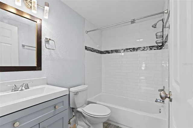 a bathroom with a sink a toilet a mirror and shower