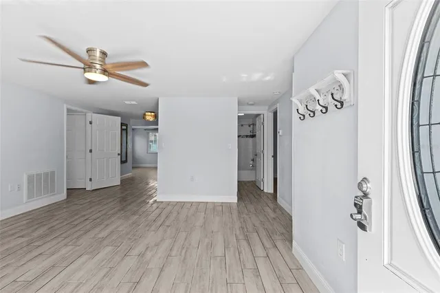 a view of a kitchen with wooden floor and a ceiling fan