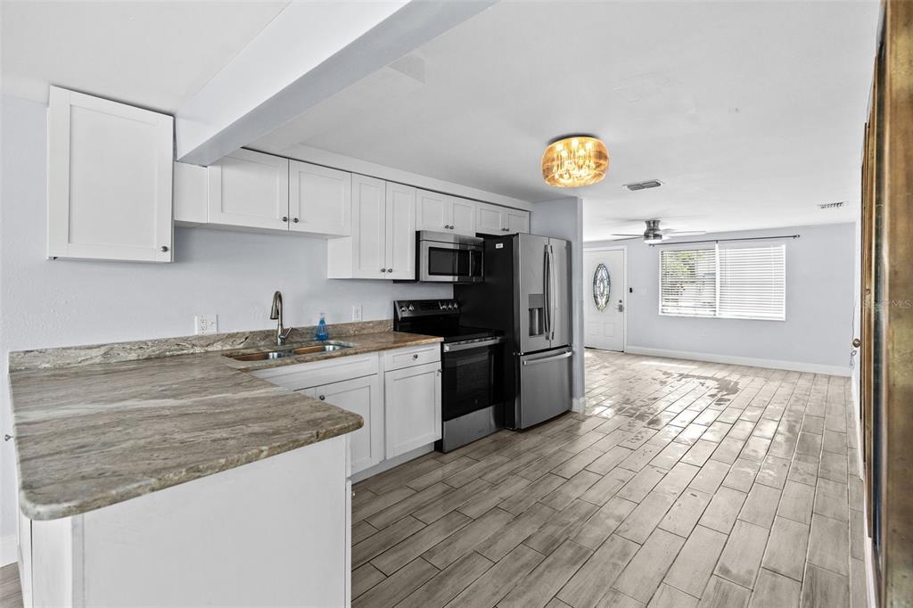 13916 Sommers Avenue Hudson, FL 34667 - Photo 10 of 46 a kitchen with granite countertop a refrigerator stove top oven and sink