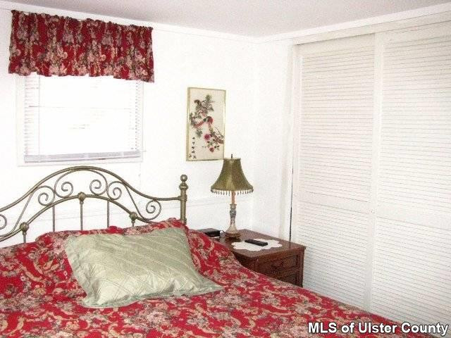 148 Rudy Frank Rd Extension Shandaken, NY 12480 - Photo 7 of 10 a bedroom with a bed and a painting on the wall