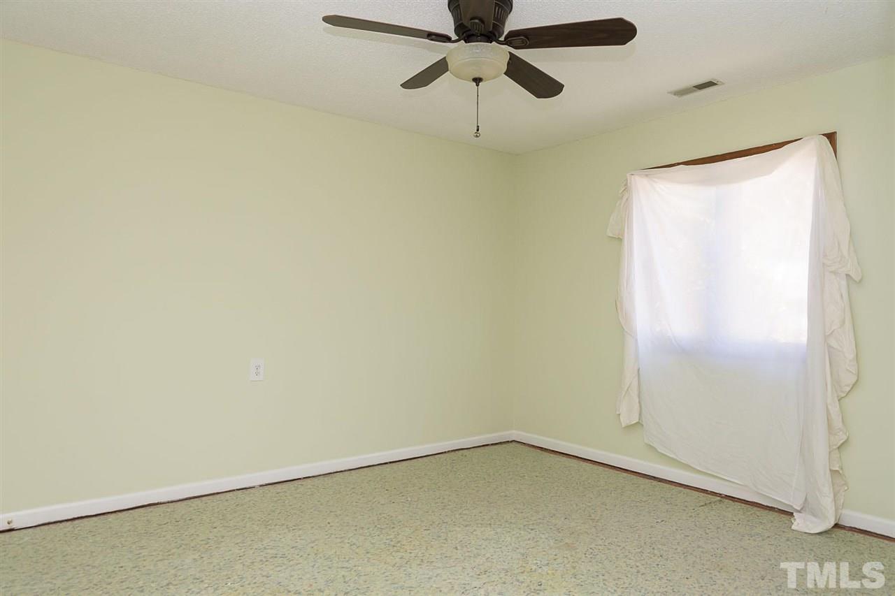 7606 Ladden Court Raleigh, NC 27615 - Photo 13 of 16 an empty room with a ceiling fan and a window