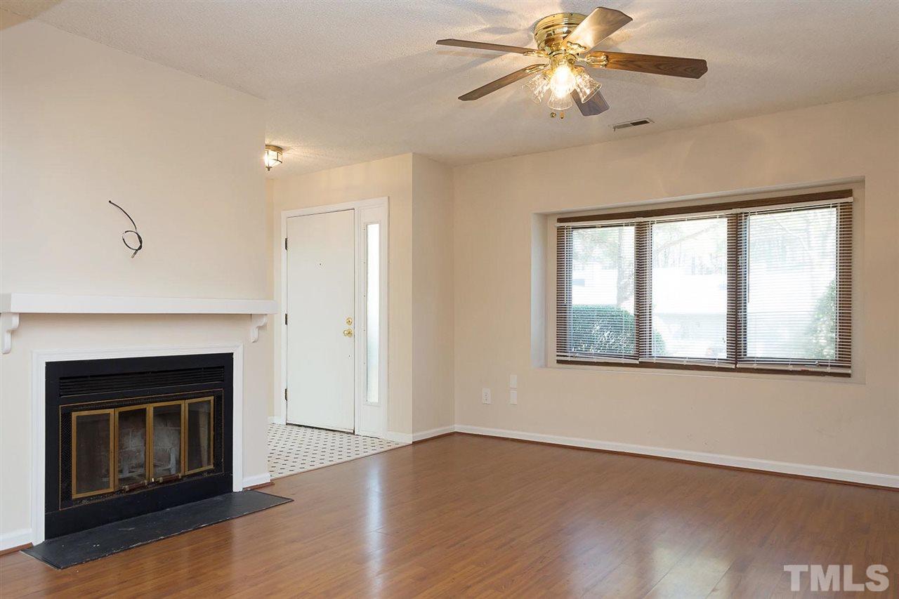 7606 Ladden Court Raleigh, NC 27615 - Photo 3 of 16 a view of an empty room with chandelier fan and wooden floor