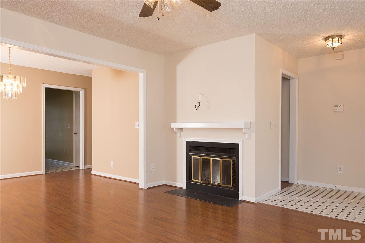 7606 Ladden Court Raleigh, NC 27615 - Photo 4 of 16 a view of a livingroom with wooden floor and a fireplace