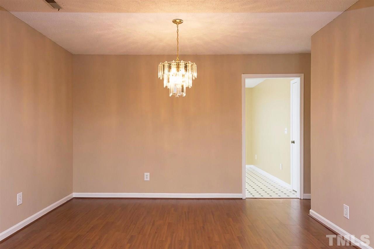 7606 Ladden Court Raleigh, NC 27615 - Photo 5 of 16 a view of a room with wooden floor and chandelier