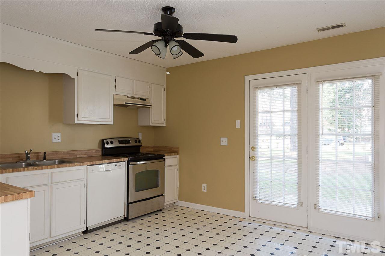 7606 Ladden Court Raleigh, NC 27615 - Photo 6 of 16 a kitchen with stainless steel appliances a sink a stove a refrigerator cabinets and a window