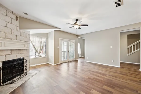 a view of an empty room with chandelier and fireplace
