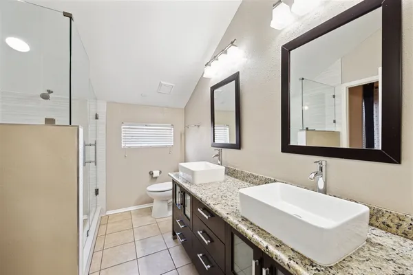 a bathroom with a double vanity sink mirror and toilet
