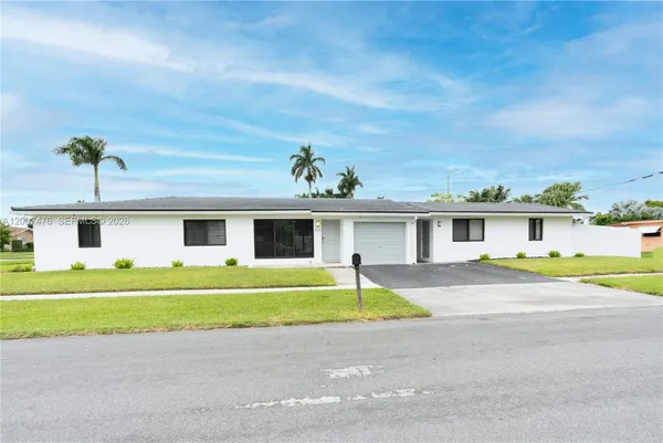 a view of a house with a backyard and a garage