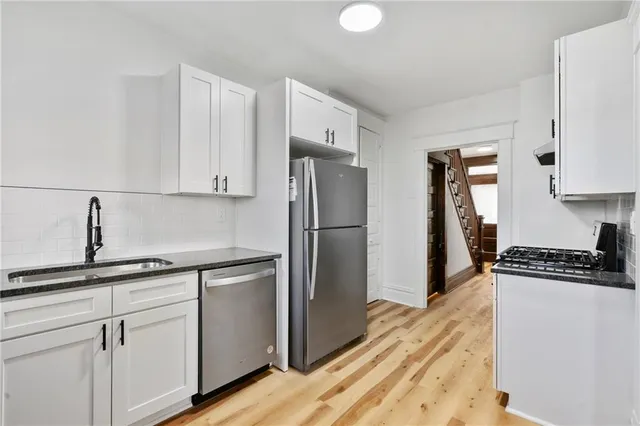 a kitchen with stainless steel appliances granite countertop a refrigerator sink and stove