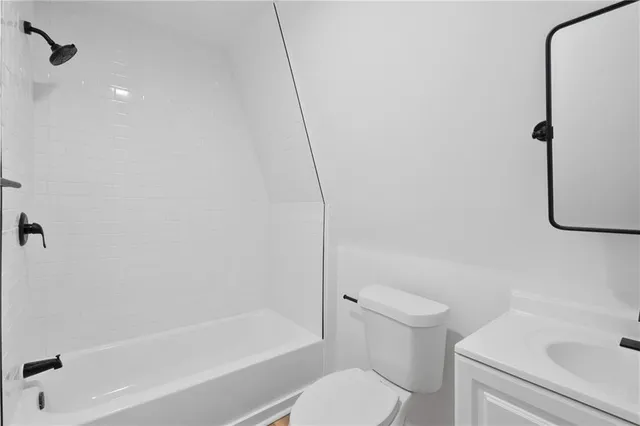 a white toilet sitting next to a bath tub