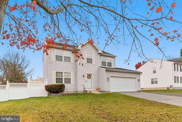 a view of a white house with a yard and garage
