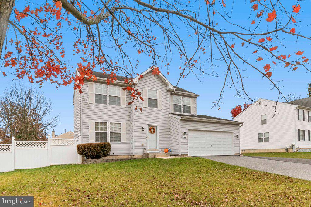 a view of a white house with a yard and garage