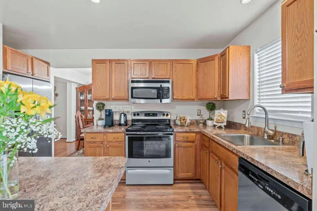 a kitchen with stainless steel appliances granite countertop a stove a sink dishwasher and a refrigerator