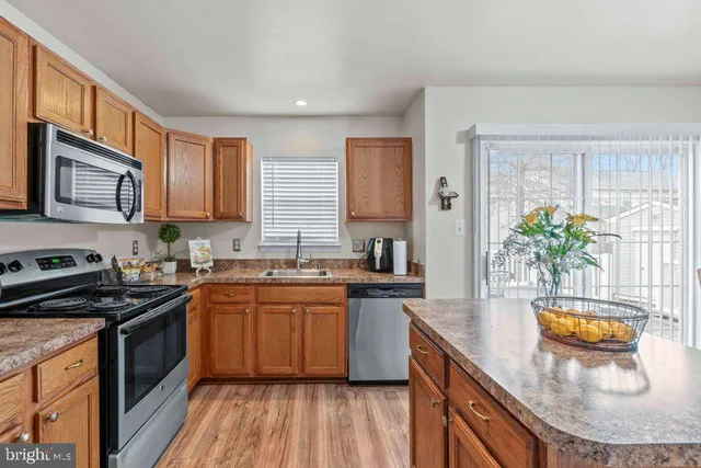 a kitchen with stainless steel appliances granite countertop sink stove top oven and microwave