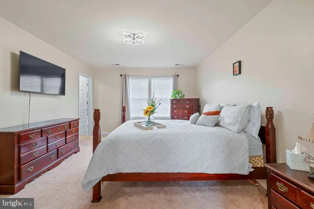 a spacious bedroom with a bed and a flat screen tv