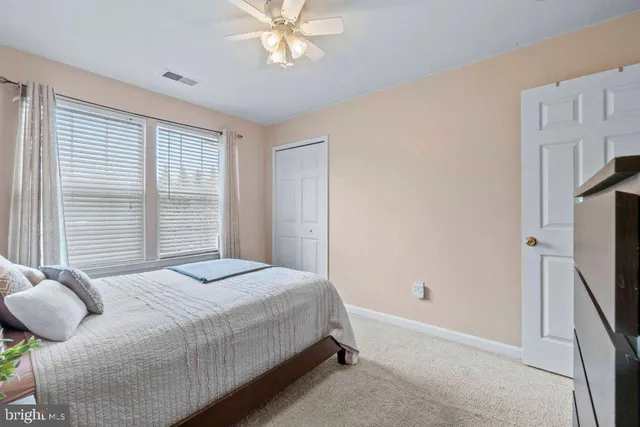 a bedroom with a bed dresser and a flat tv screen
