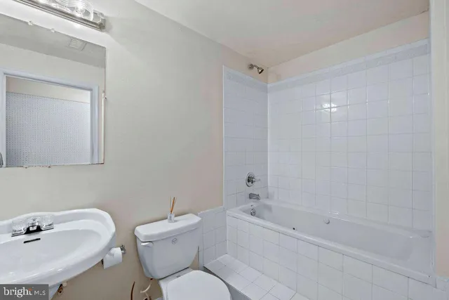 a bathroom with a sink mirror toilet and bathtub