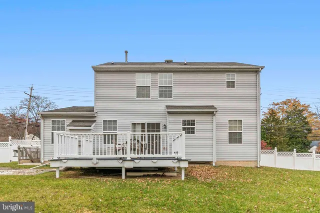 a view of a house with a small yard and wooden fence