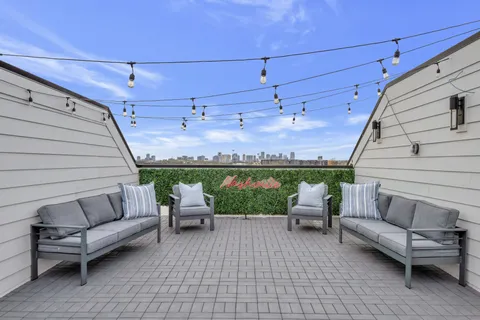 a view of a patio with couches and a table and chairs with wooden floor
