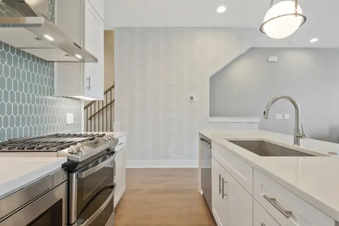 a kitchen with granite countertop a sink stove and cabinets