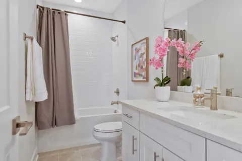 a bathroom with a granite countertop sink a mirror a shower and a bath tub