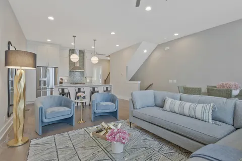 a living room with furniture and a refrigerator