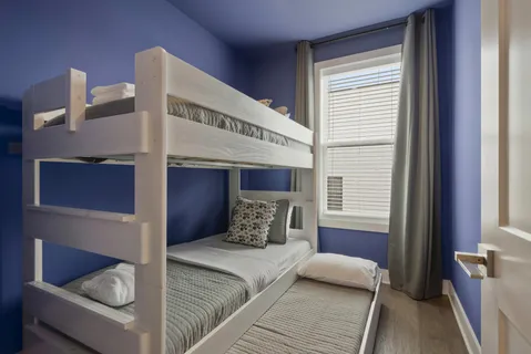 a bedroom with two beds and a large window